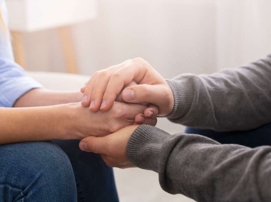 two people holding hands in individual counseling