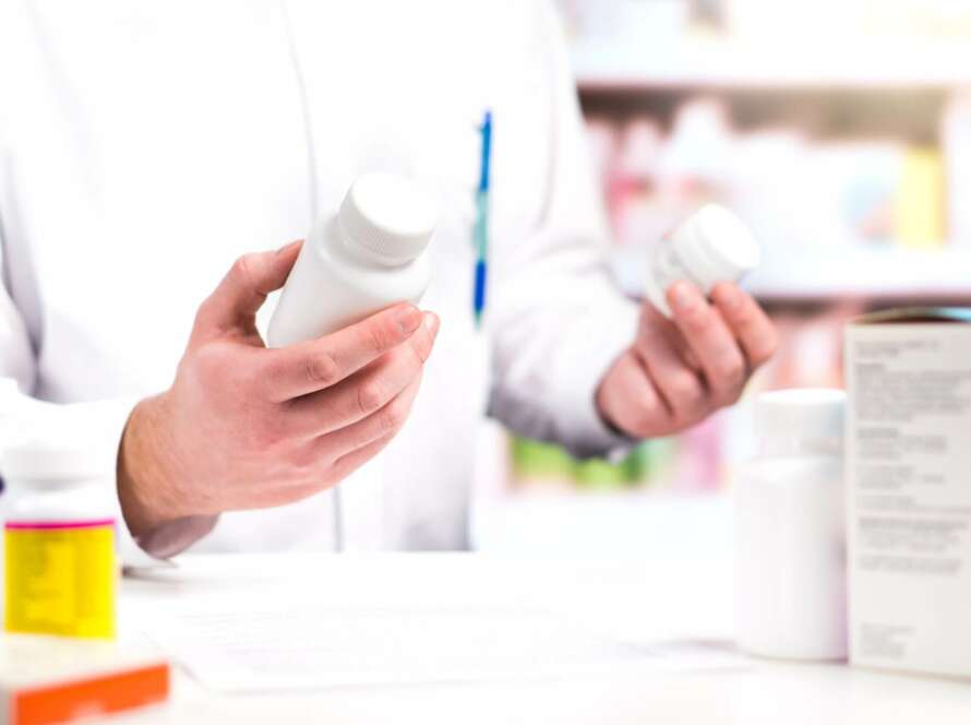 pharmacist holding two pill containers