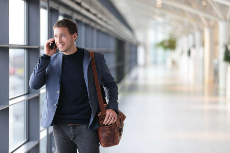 man with bag speaking on the phone